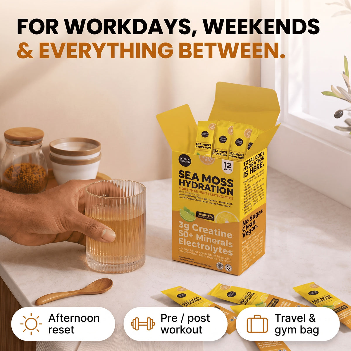 A person's hand holds a glass of light brown liquid beside an open yellow box of Sea Moss Hydration packets on a kitchen counter, with additional packets scattered nearby and promotional text at the top and bottom. prime time